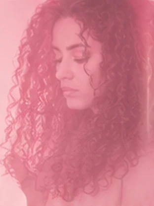 Mulher observando o cabelo sem definição no fim do dia
